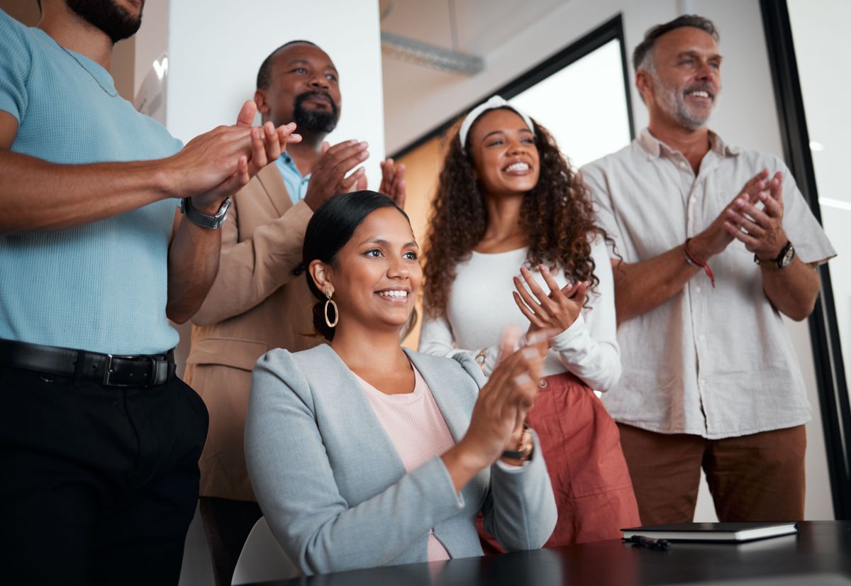 Coworkers in an office applauding and celebrating together
